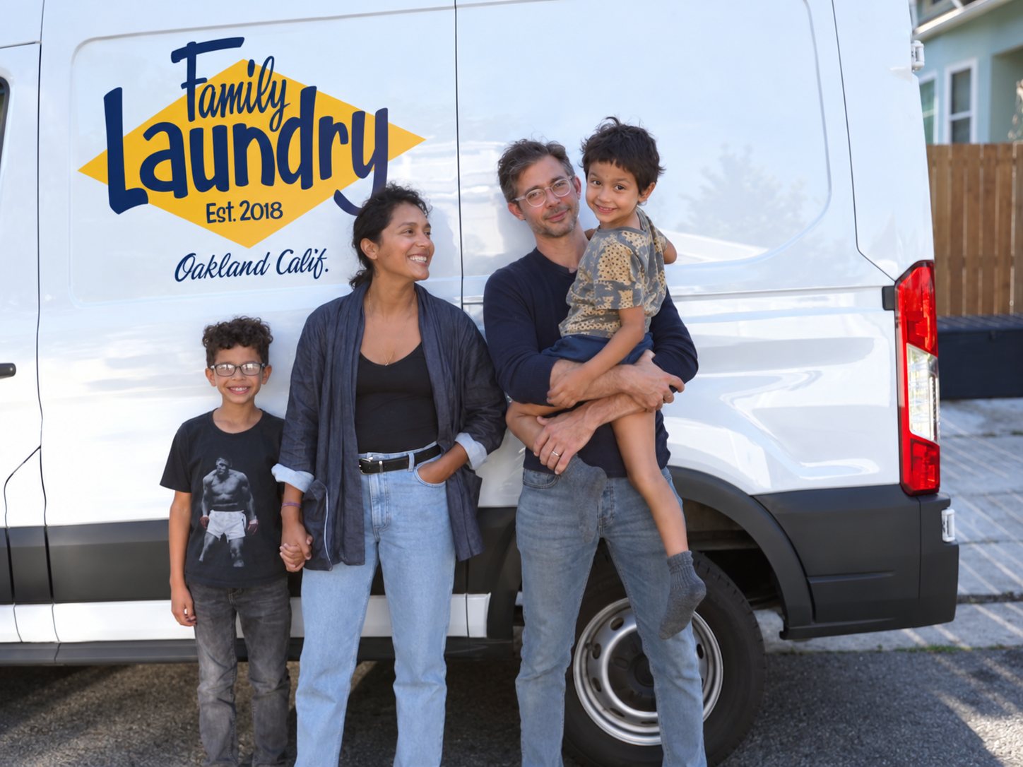 Laura, David and their two sons in front of a Family Laundry van in Oakland