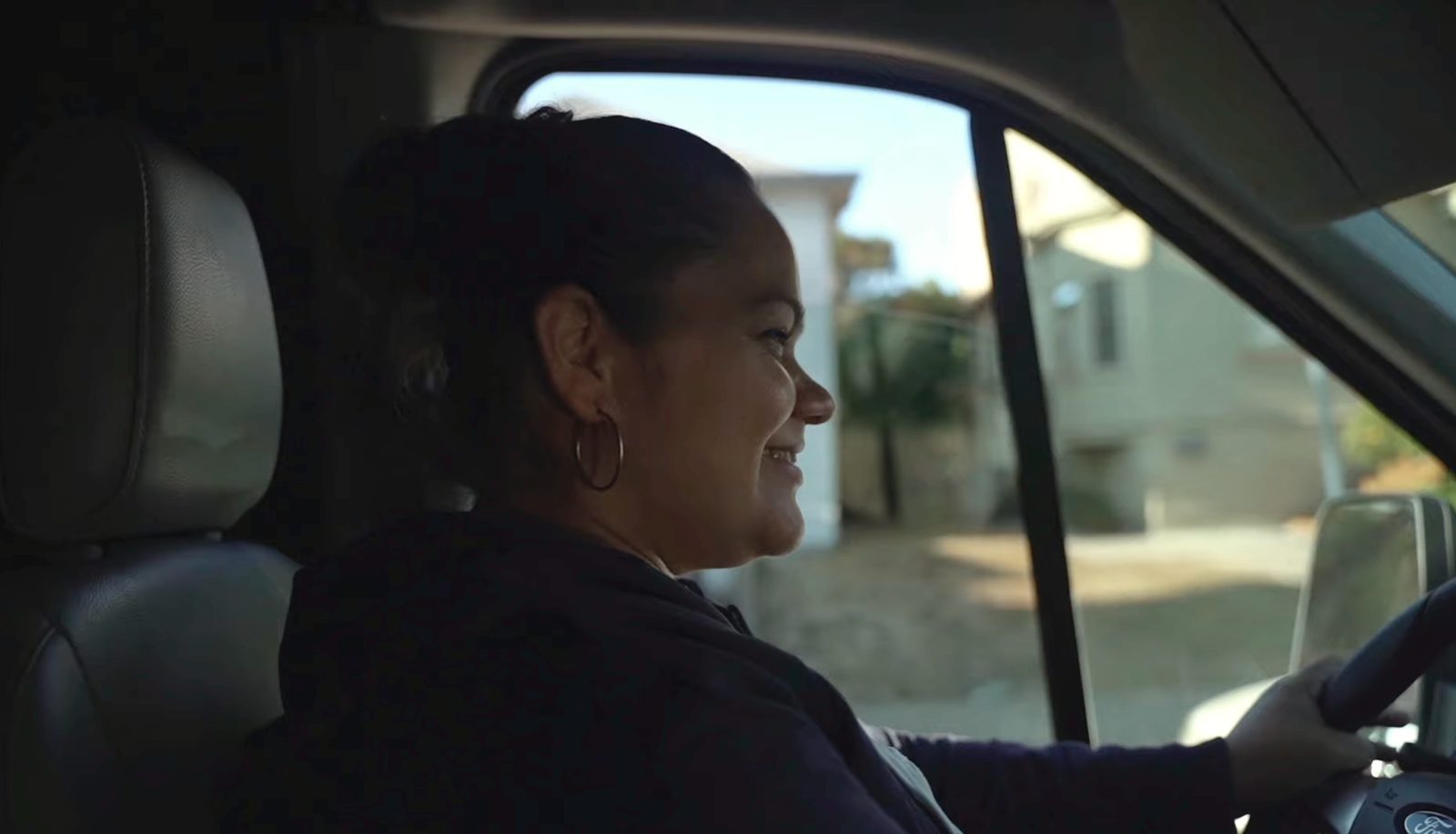 A Family Laundry driver smiling behind the wheel of the delivery van